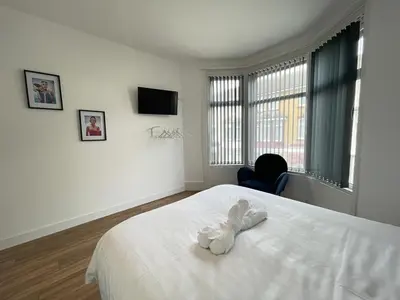a white stuffed animal sitting on a bed in a bedroom at Beach House By Sasco in Blackpool