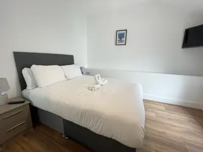 a bedroom with a bed with a stuffed animal on it at Beach House By Sasco in Blackpool