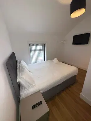 a small bedroom with a bed with a box at Beach House By Sasco in Blackpool