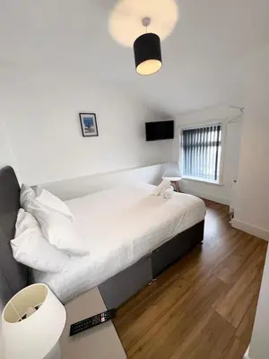 a bedroom with a large white bed in a room at Beach House By Sasco in Blackpool