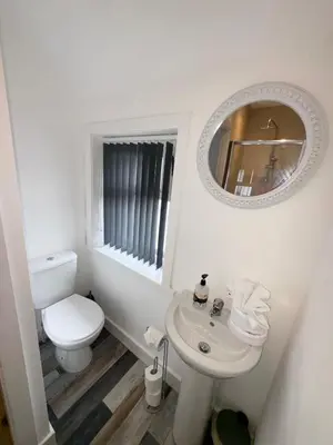 a white bathroom with a toilet and a sink at Beach House By Sasco in Blackpool