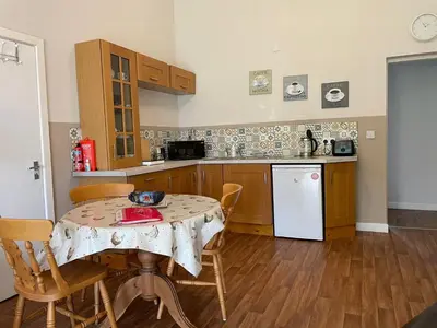 a kitchen with a table and chairs and a kitchen with a table and a counter at Formby Point in Liverpool