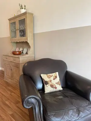 a black leather chair with a pillow in a room at Formby Point in Liverpool