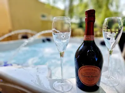 a bottle of wine and two glasses on a table at The Hamilton luxury holiday let's- The Coach House with hot tub in Scorton