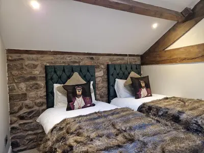 a bedroom with two beds with dolls on them at The Hamilton luxury holiday let's- The Coach House with hot tub in Scorton