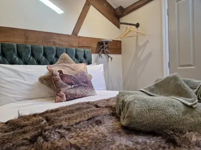a bedroom with a bed with a green headboard at The Hamilton luxury holiday let's- The Coach House with hot tub in Scorton