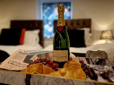 a bottle of wine sitting on a table with food at The Hamilton luxury holiday let's- Holly Barn in Scorton