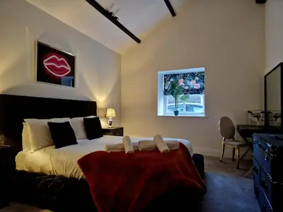 a bedroom with a bed with a red blanket on it at The Hamilton luxury holiday let's- Holly Barn in Scorton