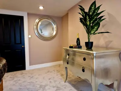 a potted plant on a dresser with a bottle of champagne at Hamilton-The Alexander suite luxury holiday Let's in Scorton