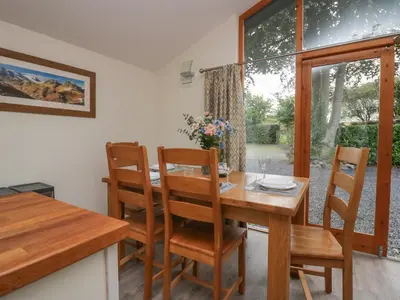 a dining room with a wooden table and chairs at Bay Tree Lodge in Grange Over Sands