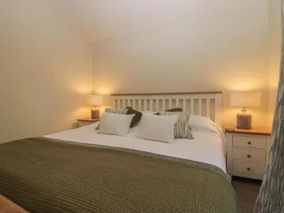 a bedroom with a large white bed with pillows at Bay Tree Lodge in Grange Over Sands