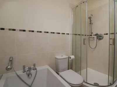 a bathroom with a shower and a toilet and a tub at Bay Tree Lodge in Grange Over Sands