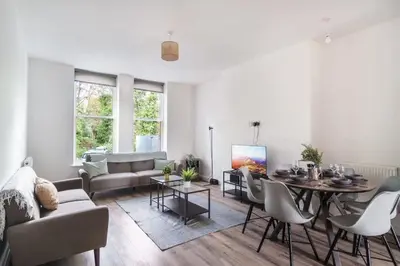 a living room with a couch and a table at Spacious 3 Bed Apartment in Waterloo Liverpool in Waterloo
