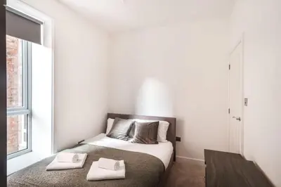 a bedroom with a bed with two towels on it at Spacious 3 Bed Apartment in Waterloo Liverpool in Waterloo
