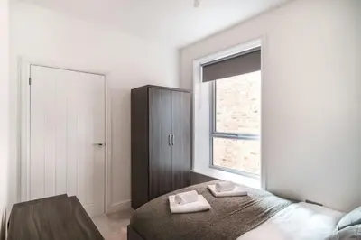 a bedroom with a bed with two towels on it at Spacious 3 Bed Apartment in Waterloo Liverpool in Waterloo