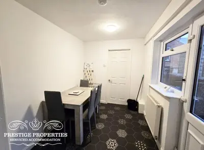 a dining room with a table and chairs and a window at 31 Westmorland Street by Prestige Properties SA in Barrow in Furness