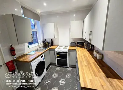 a kitchen with white cabinets and a stove top oven at 31 Westmorland Street by Prestige Properties SA in Barrow in Furness