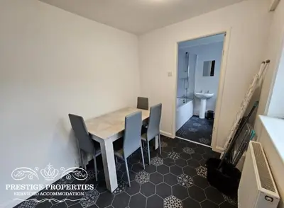 a dining room with a table and chairs and a bathroom at 31 Westmorland Street by Prestige Properties SA in Barrow in Furness