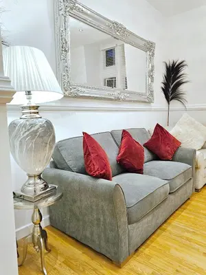 a gray couch with red pillows in a living room at Sidemersey Livings - Spacious Loft for bigger groups - Very Central and Cosy in Liverpool