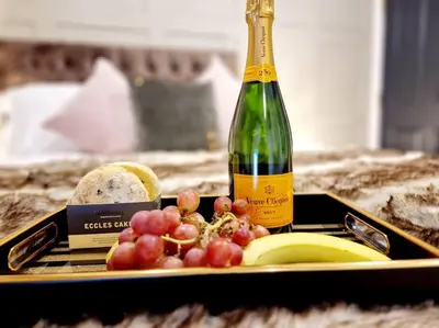 a bottle of wine next to a plate of fruit at Hamilton-The Cruck Luxury Let in Scorton