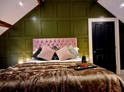 a bedroom with a large bed with a pink headboard at Hamilton-The Cruck Luxury Let in Scorton