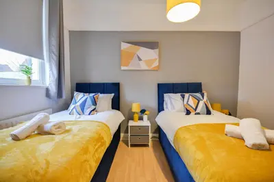two beds sitting next to each other in a bedroom at Beautiful Stylish 2BD Flat - Free Parking 30 Percent Off Long term bookings in Wallasey