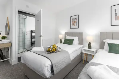 a bedroom with two beds and a table with oranges on a tray at Host Liverpool - The Wavertree Rooms in Liverpool