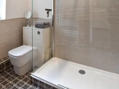 a bathroom with a shower and a toilet and a tub at Mount Cottage in Wennington