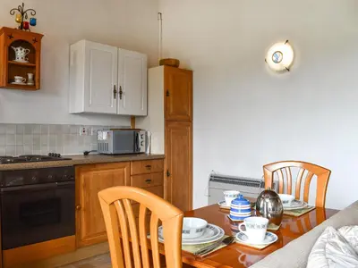 a kitchen with a wooden table and a kitchen with a microwave at Mount Cottage in Wennington