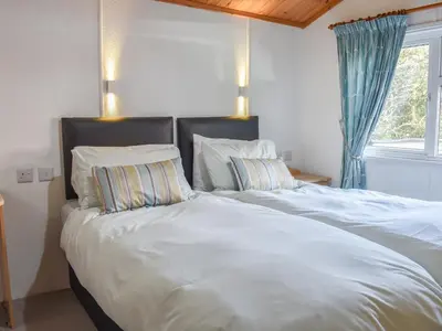 a bedroom with two beds with white sheets and pillows at Serenity in Millom