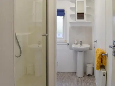 a bathroom with a shower and a sink at Serenity in Millom