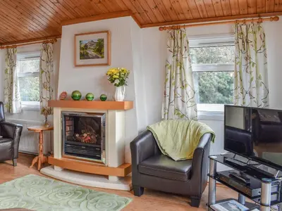 a living room with a fireplace and a tv at Serenity in Millom