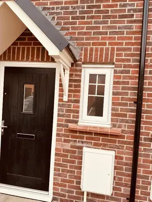 a brick house with a black door and two windows at Newhaven House in Liverpool