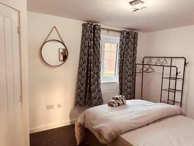 a bedroom with a bed and a mirror and a window at Newhaven House in Liverpool