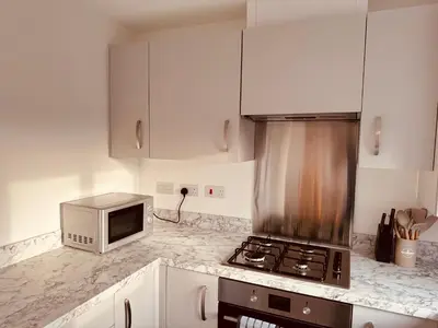 a kitchen with a stove top oven next to a microwave at Newhaven House in Liverpool
