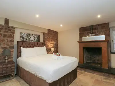 a bedroom with a large bed with a fireplace at Lord William in Preston