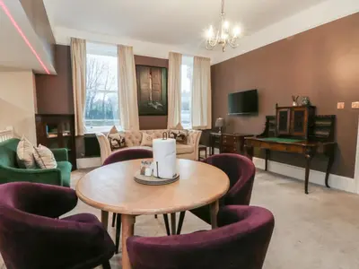 a living room with a table and chairs and a piano at Lord William in Preston