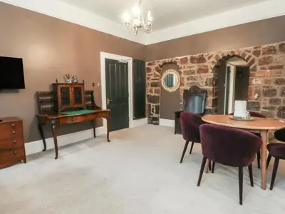 a living room with a table and a desk and a tv at Lord William in Preston