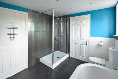 a bathroom with a tub and a shower and a toilet at Huntsfield House- Stunning Modern 4 Bedroom House Suitable for Work and Leisure Stays in Bamber Bridge