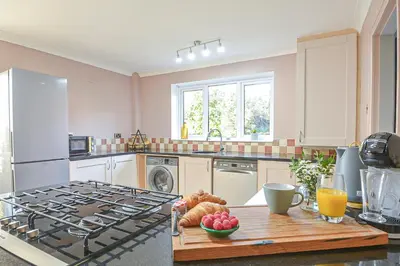 a kitchen with a stove and a table with fruit on it at Huntsfield House- Stunning Modern 4 Bedroom House Suitable for Work and Leisure Stays in Bamber Bridge