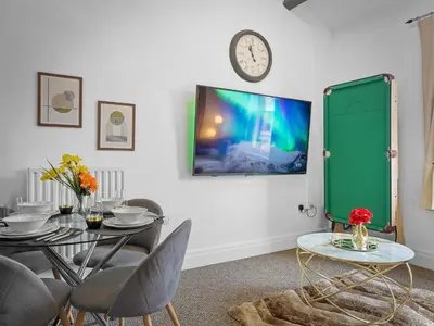 a dining room with a table and a green cabinet at Preston Serviced Apartment - Estatevision in Preston