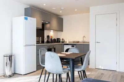a kitchen with a table and chairs and a refrigerator at GuestReady - Elegant Tranquility in Vauxhall in Liverpool