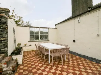 a white table and chairs on a patio at Penny Bridge House in Ulverston