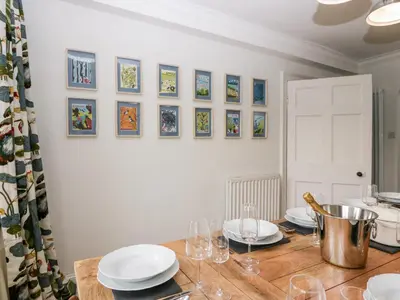 a dining room with a table with plates and wine glasses at Penny Bridge House in Ulverston