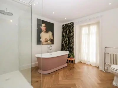 a bathroom with a bath tub and a toilet at Penny Bridge House in Ulverston