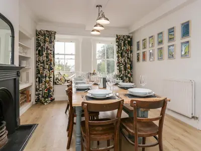 a dining room with a table and chairs and a fireplace at Penny Bridge House in Ulverston