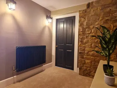a hallway with a black door and a stone wall at Hamilton - Lord William in Scorton