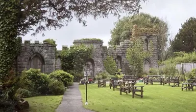 a stone building with tables and benches in a park at Lonsdale House Boutique Apartments in Ulverston