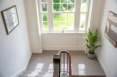 a staircase with arolley in front of a window at Lonsdale House Boutique Apartments in Ulverston