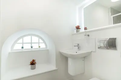 a white bathroom with a sink and a window at Lonsdale House Boutique Apartments in Ulverston